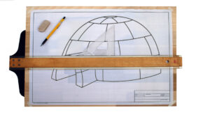 architects drawing board with a pencil, a triangle, a Tsquare and a drawing of an igloo