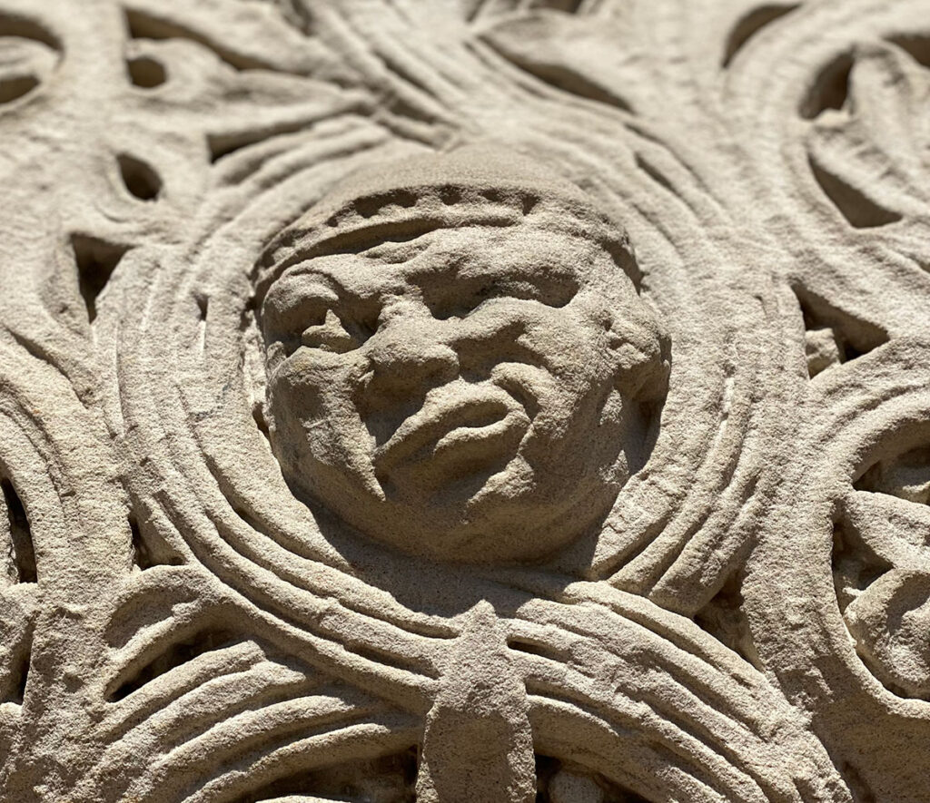 decorative gargoyle on a building of a facethat looks angry